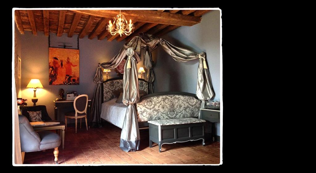 sypialnia z łóżkiem z baldachimem i krzesłem w obiekcie Manoir de Livet w mieście Saint-Germain-de-Livet