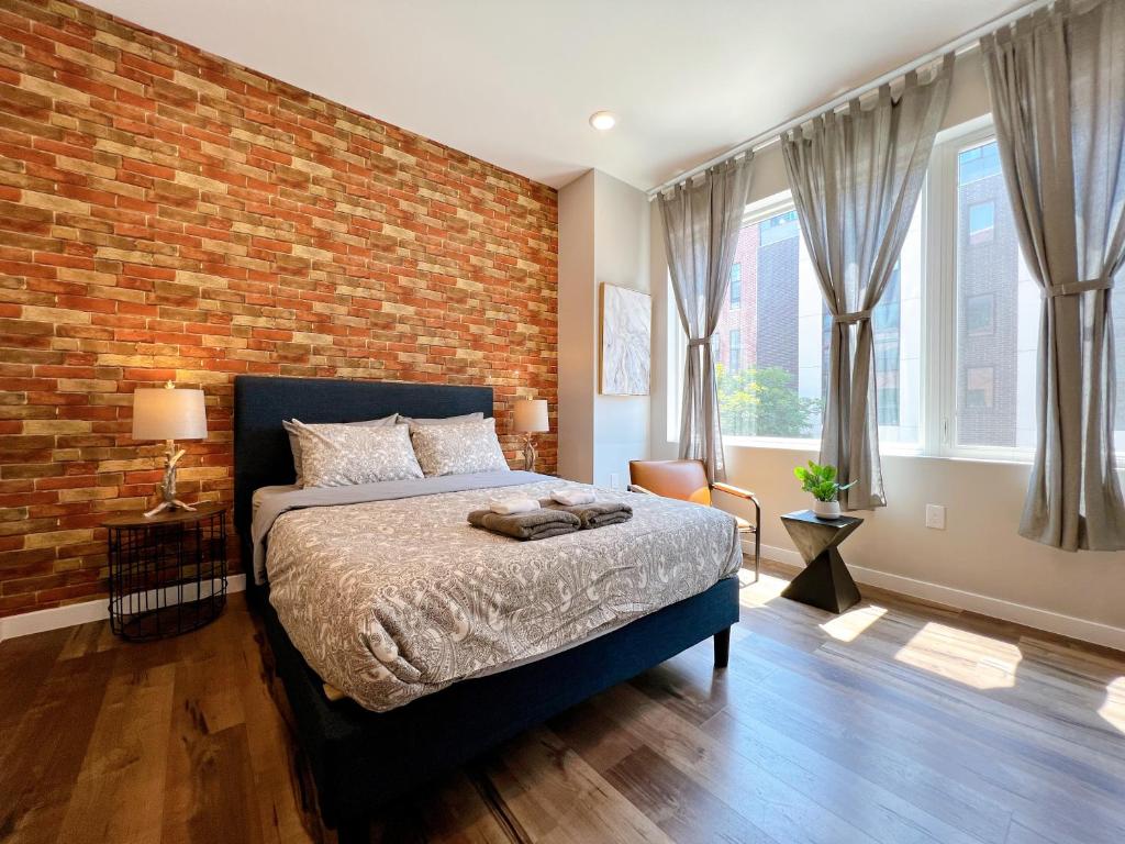 a bedroom with a brick wall and a bed at Stay at Luna on Ridge Ave in Philadelphia