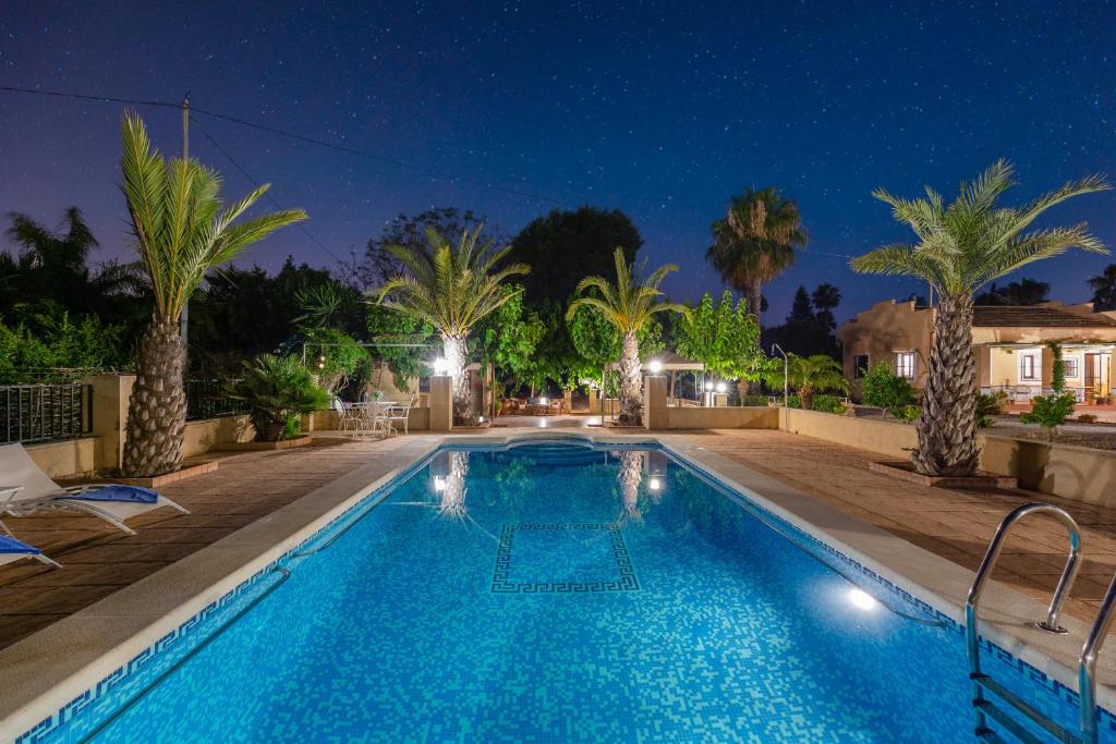 uma piscina com palmeiras em frente a uma casa em Harmony Villa by Fidalsa em Daya Vieja