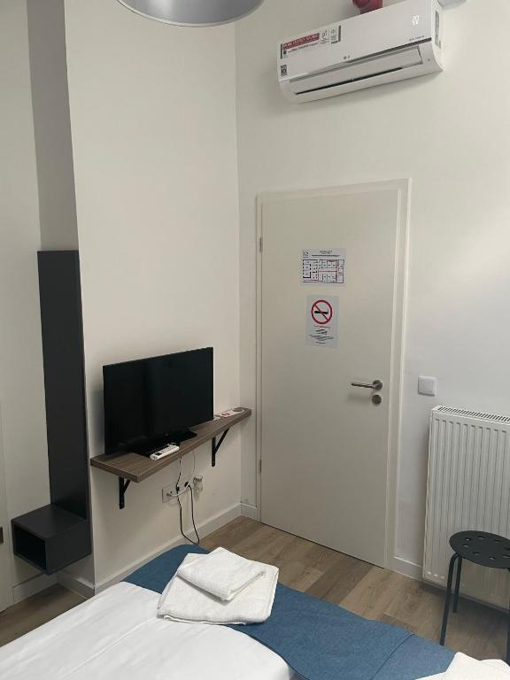 a room with a bed and a door with a television at RES City Residence Hotel Budapest in Budapest