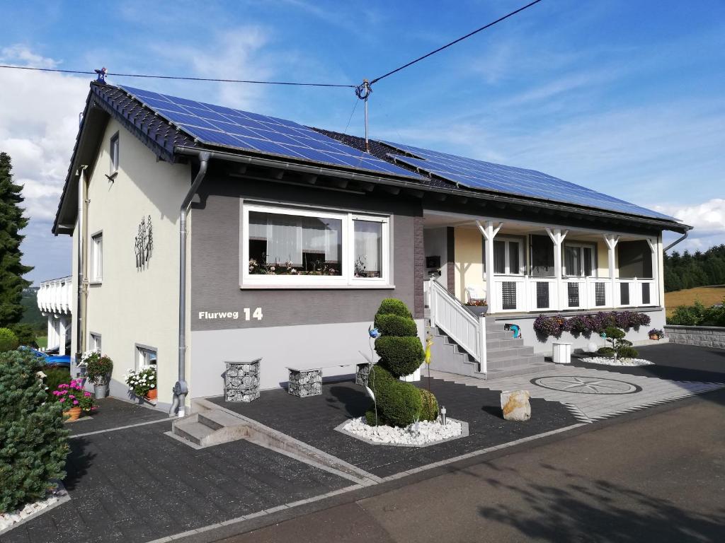 una casa con paneles solares en el techo en Ferienwohnung Altmaier - Ferien auf dem Lande, en Griebelschied
