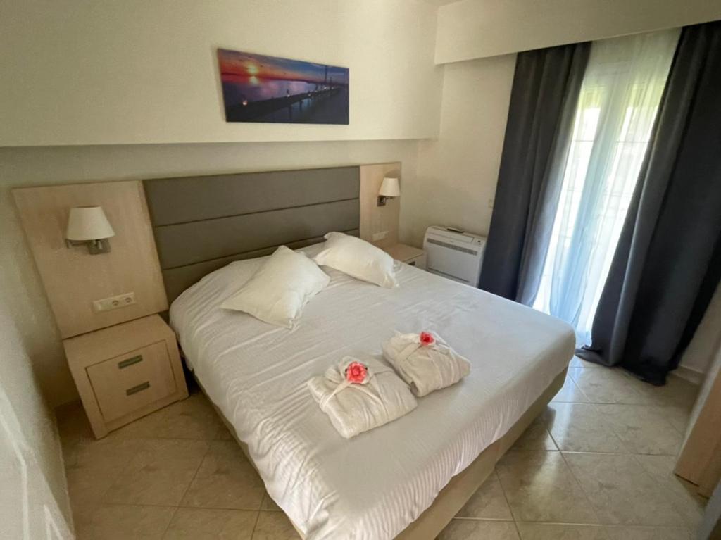 ein Schlafzimmer mit einem weißen Bett mit zwei Handtüchern darauf in der Unterkunft ANGELIKA HOUSE 2 in Marathias