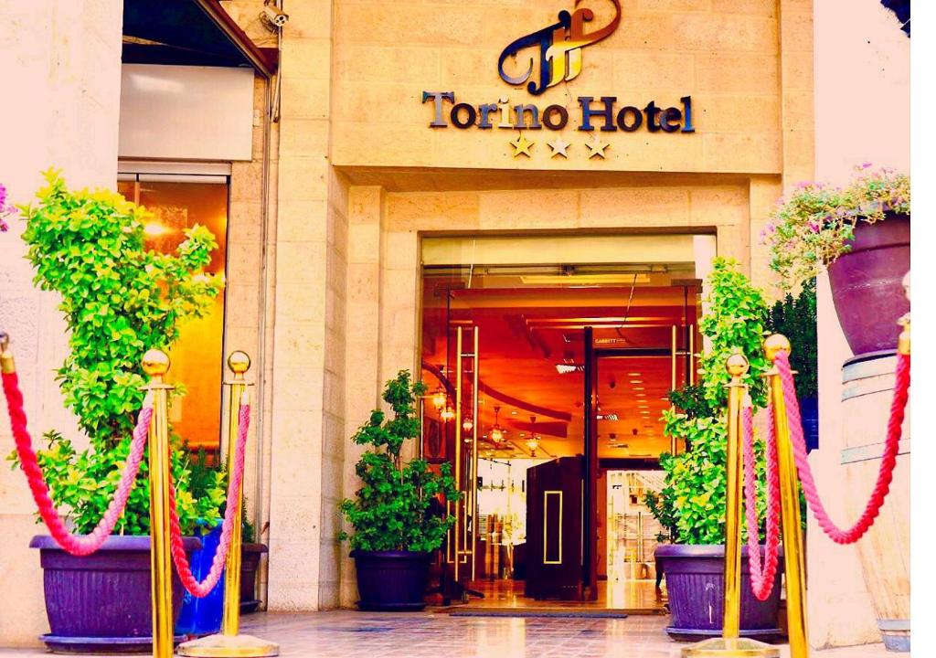 un hotel tono con plantas delante de él en Torino Hotel Amman, en Amán