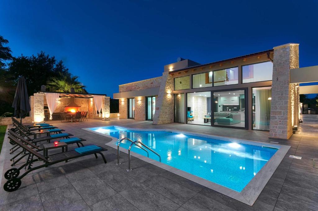 una casa con piscina frente a una casa en Villa Potami Nikos by Villa Plus en Stílos