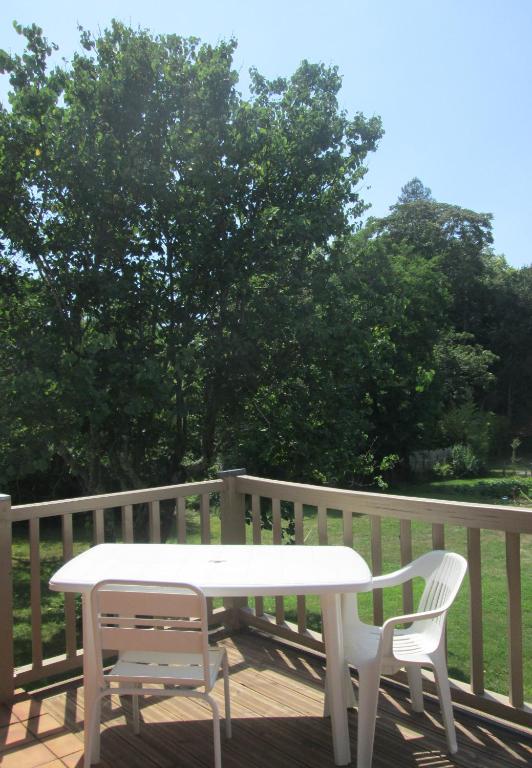une table blanche et deux chaises sur une terrasse dans l'établissement Hope's Land - gîte, à Onesse-et-Laharie