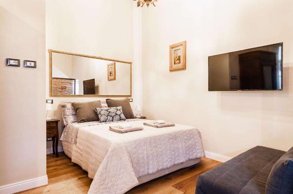 a bedroom with a bed and a flat screen tv at Il nido in centro in Lucca