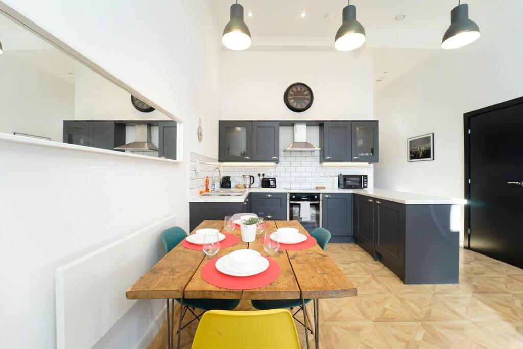 een keuken met een houten tafel en gele stoelen bij Spacious 2 bedroom city centre apartment in Leeds