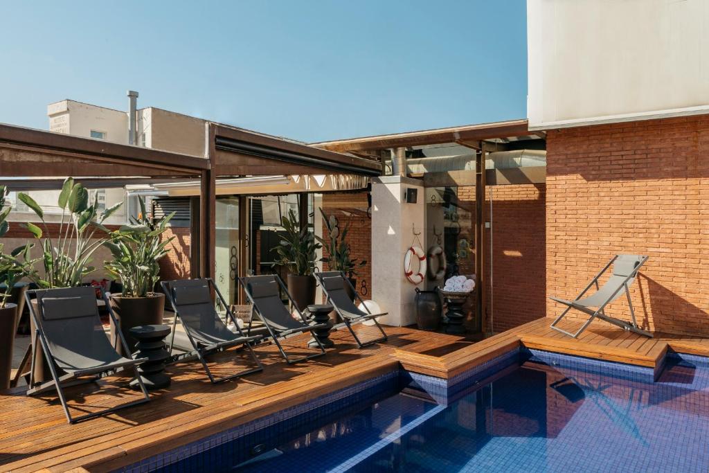 a patio area with a pool, chairs, and a tub at Hotel Granados 83, a Member of Design Hotels in Barcelona