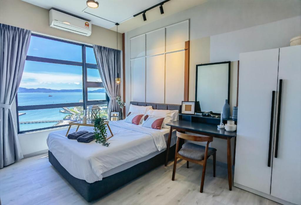 a bedroom with a desk and a bed with a window at Lavender Homes @ Jesselton Quay Kota Kinabalu in Kota Kinabalu