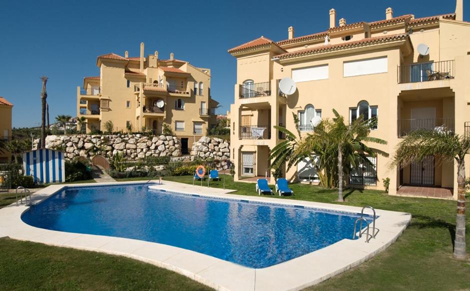 a villa with a swimming pool in front of a building at CT 184 - Atalaya del Sol in Mijas Costa
