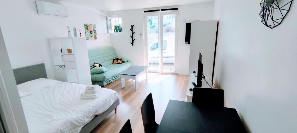 une petite chambre avec un lit et un canapé dans l'établissement Appartement climatisé Golfe-Juan plage, à Vallauris