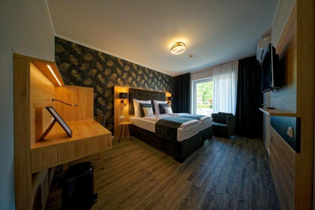 une chambre d'hôtel avec un lit et une télévision dans l'établissement Hotel Dea, à Soltau