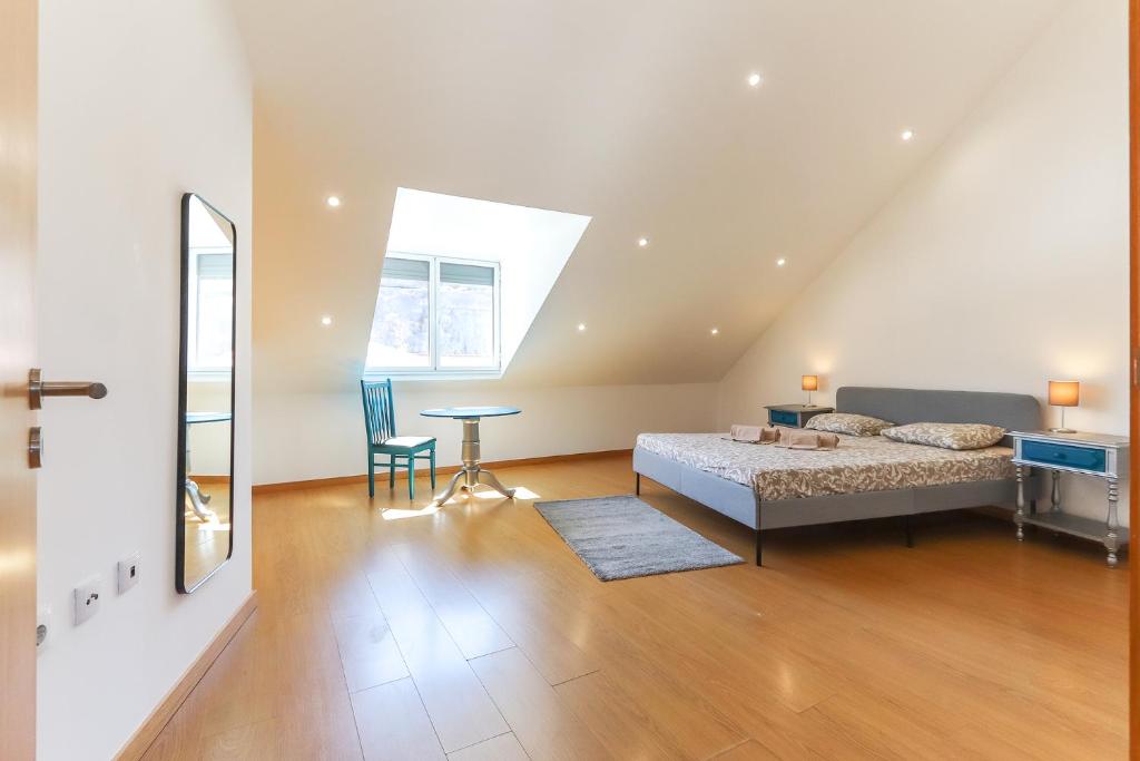 1 dormitorio con cama, mesa y espejo en Vita Portucale ! Concept Apartment Campo Ourique en Lisboa