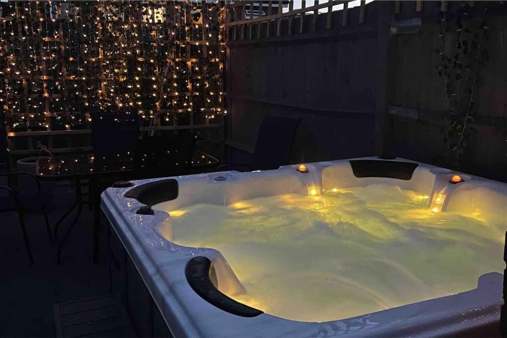 a jacuzzi tub on a balcony at night at Elmside, The Luxury New Forest Retreat in Southampton