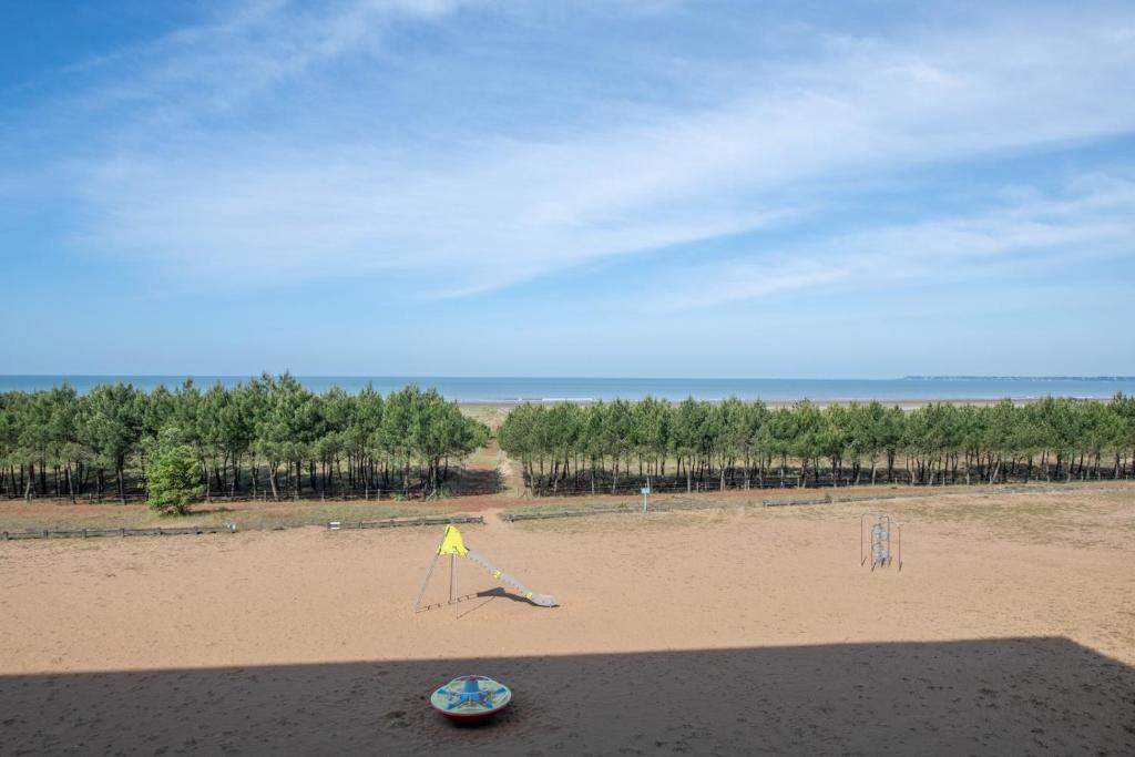 a beach with a sign in the sand at Appartement face mer et aux pins in Saint-Brevin-les-Pins
