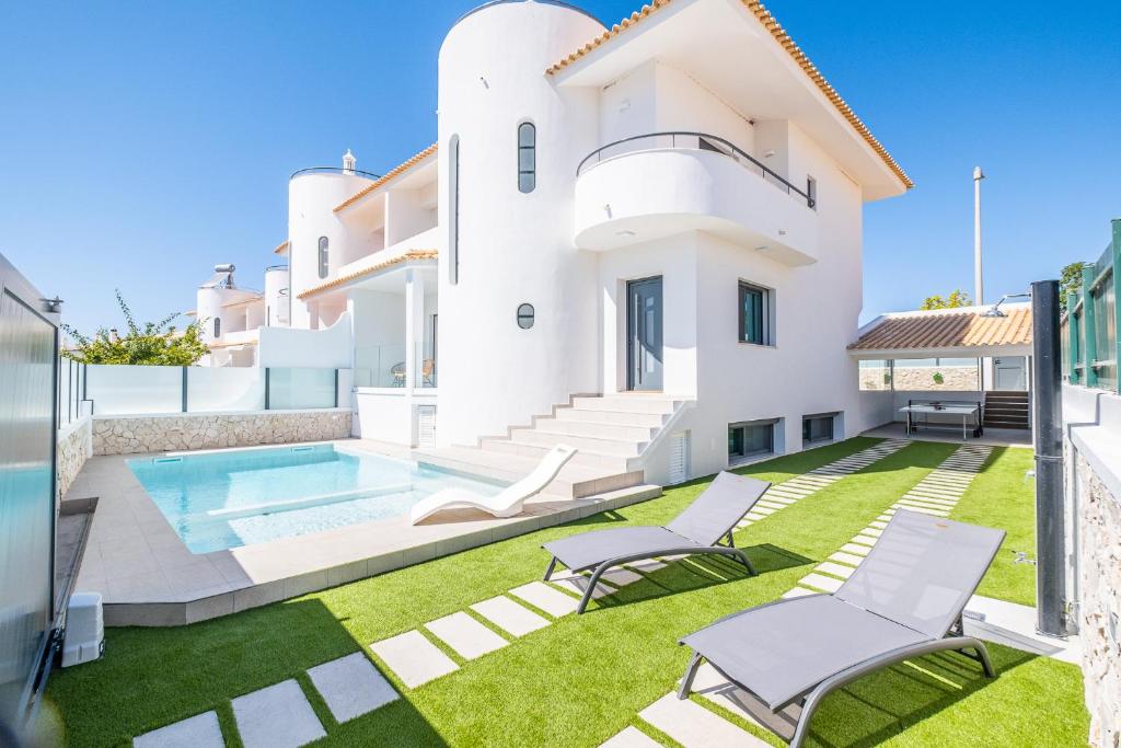 a villa with a swimming pool and lawn at Atlantis Luxury Villa in Guia