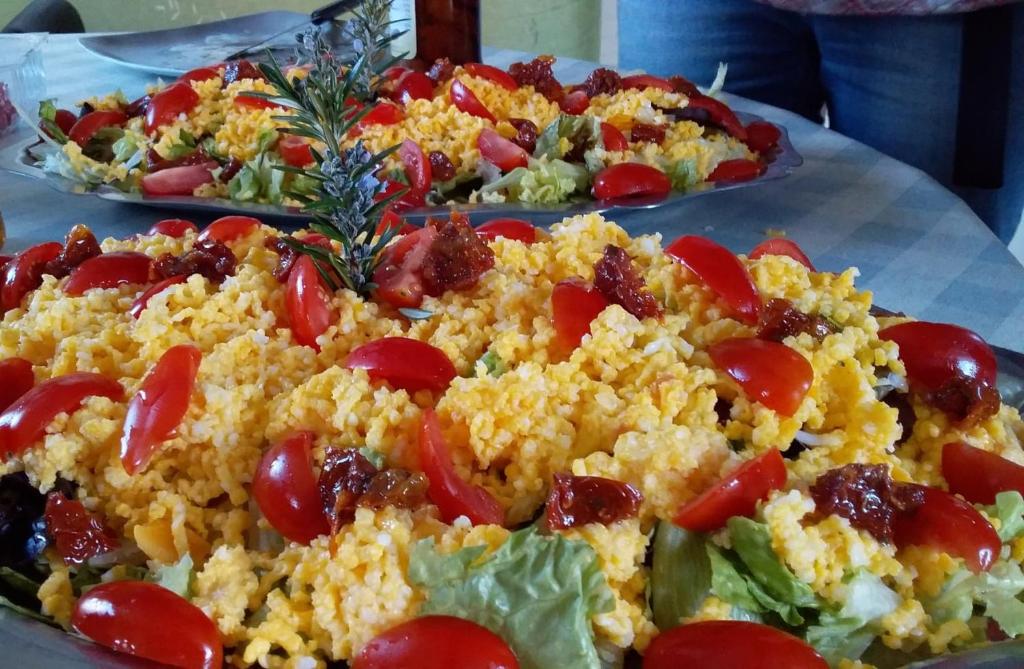 dos platos de comida con tomates y lechuga en una mesa en Le Ranch du Madres en Roquefort-de-Sault