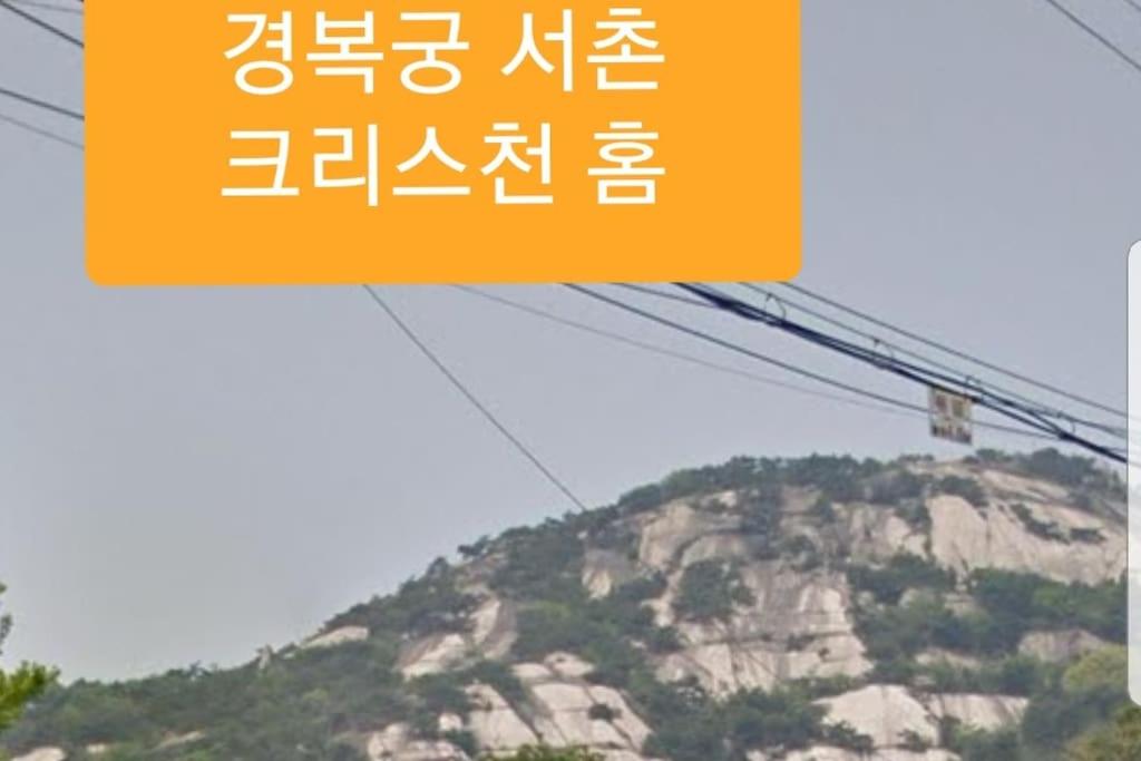 um sinal numa língua asiática com uma montanha em Gyeongbokgung Palace Seochon Christian Home - Foreigner Only em Seul