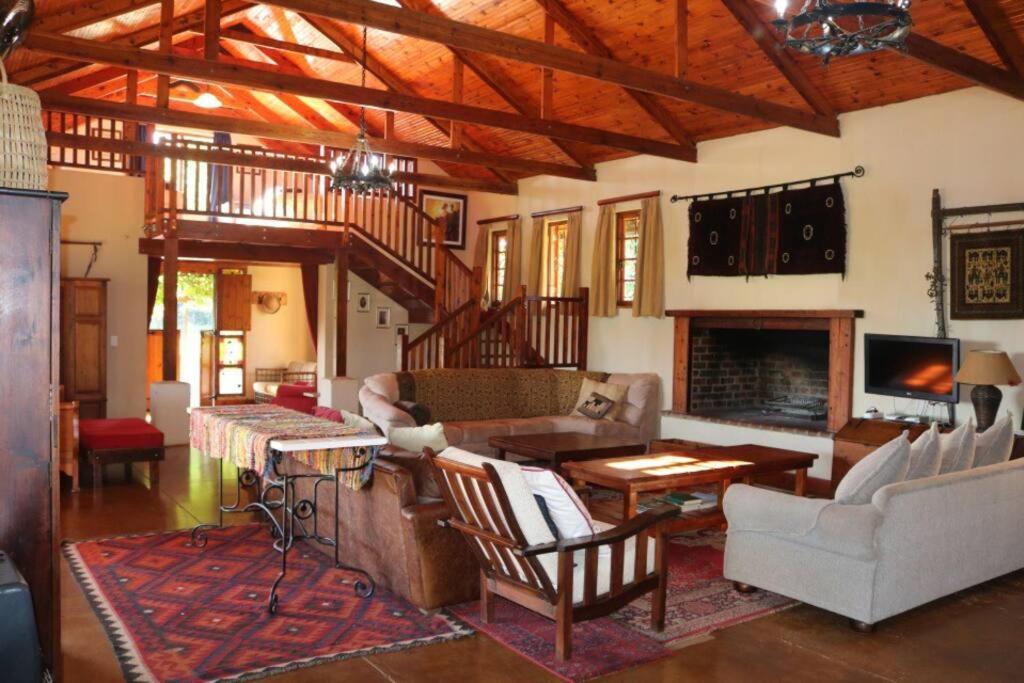 een woonkamer gevuld met meubels en een open haard bij Cedarwood Guest House in Howick
