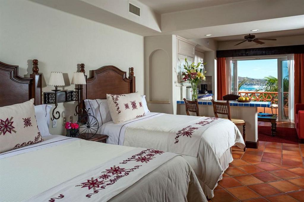 a hotel room with two beds and a balcony at Suites at Hacienda Del Mar Resort Los Cabos in Cabo San Lucas