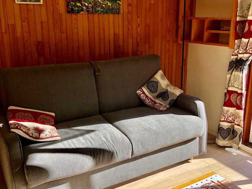 - un canapé dans le salon avec des oreillers dans l'établissement Charmant 2 pièces pour 4 personnes avec balcon, centre de Valloire, proche des pistes et commerces - FR-1-263-46, à Valloire