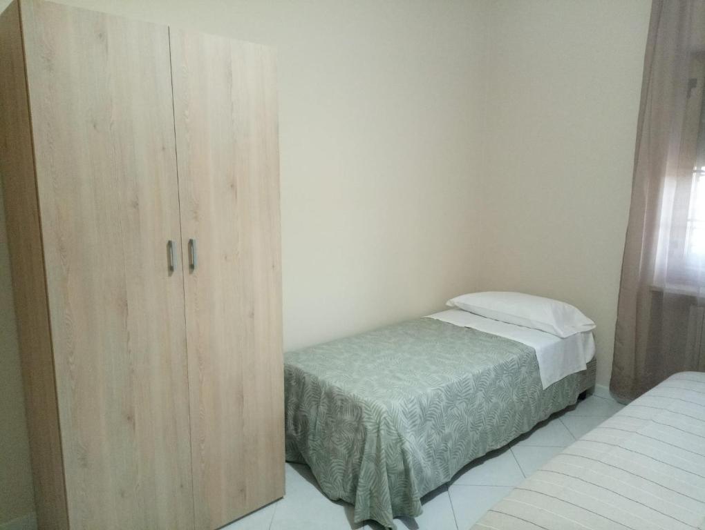 a small bedroom with a bed and a cabinet at La Fattoria B&B in San Marco Argentano