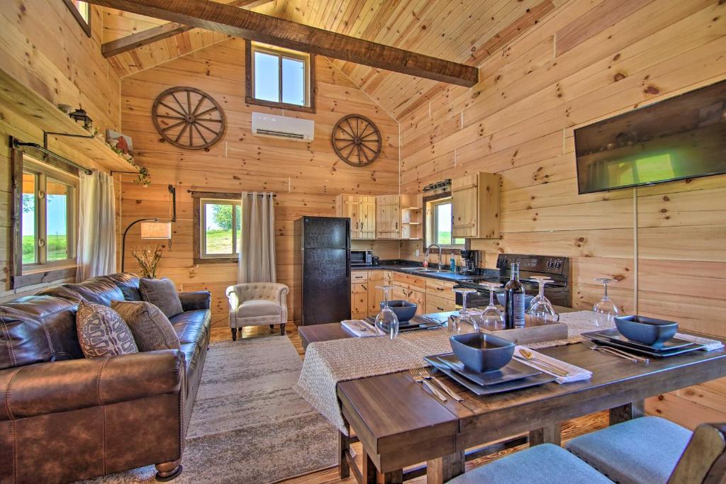 een woonkamer met een bank en een tafel bij Peaceful Blanchardville Cabin on 35-Acre Farm 