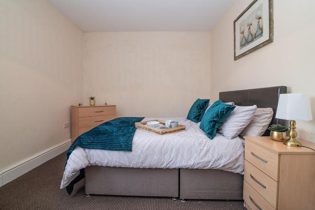 1 dormitorio con 1 cama grande con almohadas azules en Lovely 1 bed apart.Contractors.NearRussellHillHosp, en Brierley Hill