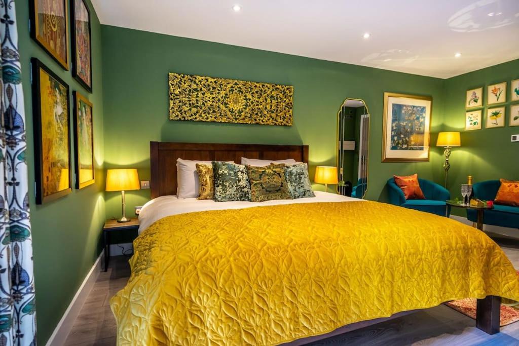 um quarto com uma cama amarela e paredes verdes em The Boutique York Garden Studio em York