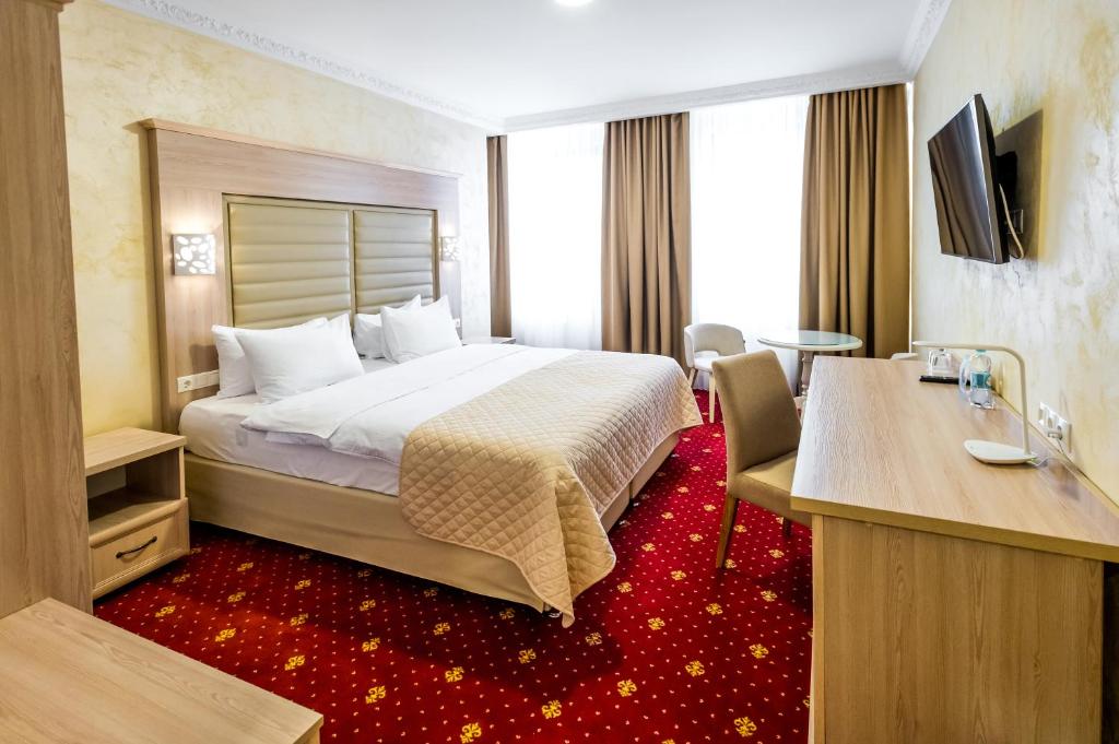 a hotel room with a bed and a desk at Hotel France in Vinnytsya