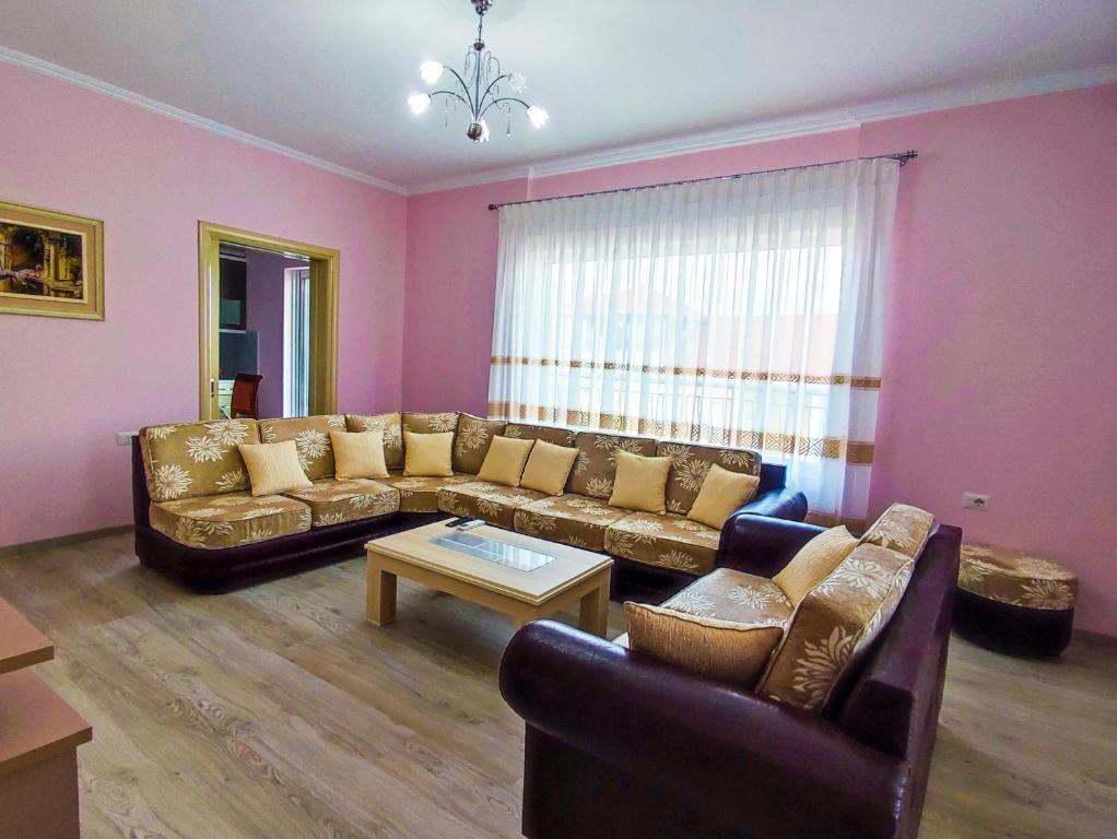 uma sala de estar com um sofá e uma mesa em Cheerful 2 bedroom villa with free parking. em Gjirokastër