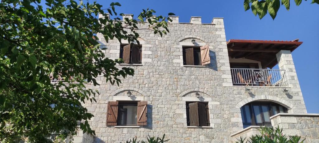 un edificio de piedra alto con ventanas. en Atha-Tina:Traditional Stone Homes en Agios Nikolaos