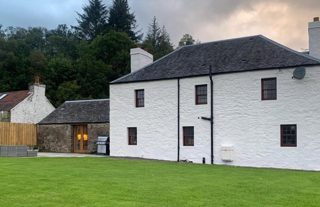 a large white house with a grassy yard at Old Tynribbie House - Comfortable Detached House in Appin