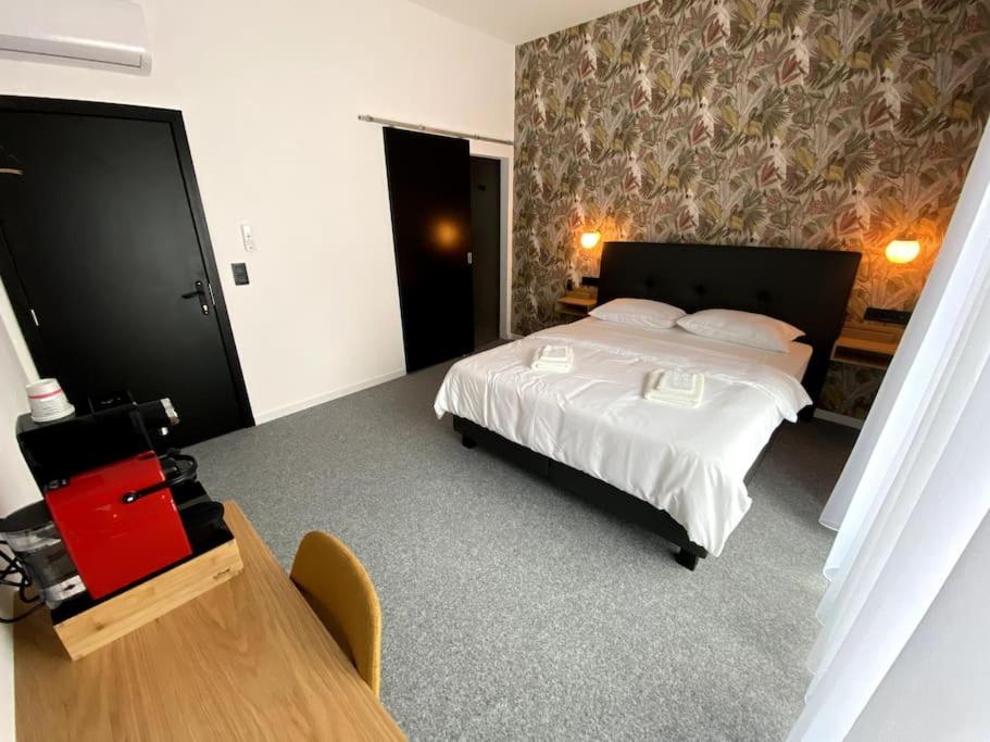 a bedroom with a bed and a desk and a table at BED Cauchy in Namur