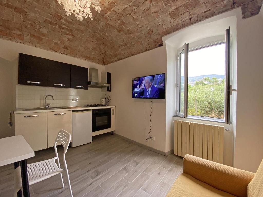 uma sala de estar com uma cozinha e uma janela em LA CASA DEL BORGO nature sport & relax Big Loft em Calice Ligure