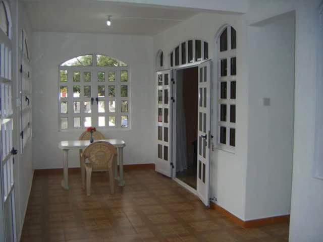 a room with a table and a table and a door at Albamauritius B&B in Belle Mare