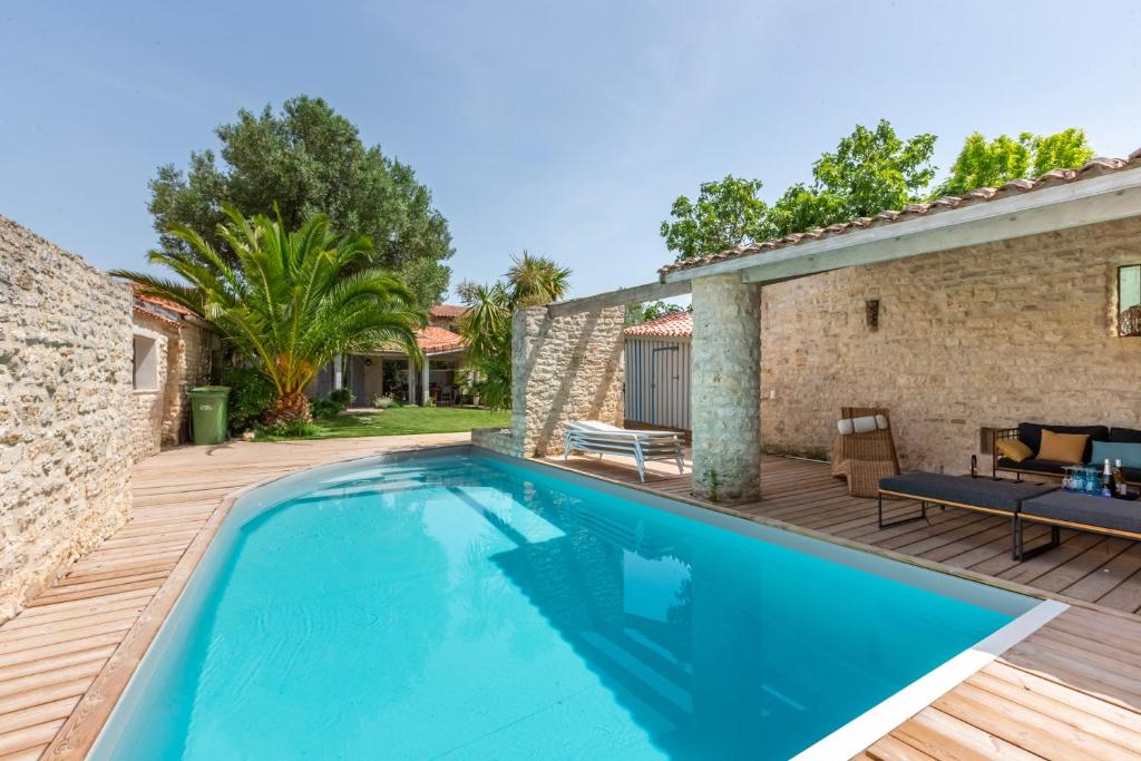 - une piscine avec une terrasse et une maison dans l'établissement Le Chai de La Boirie, à Saint-Pierre-dʼOléron