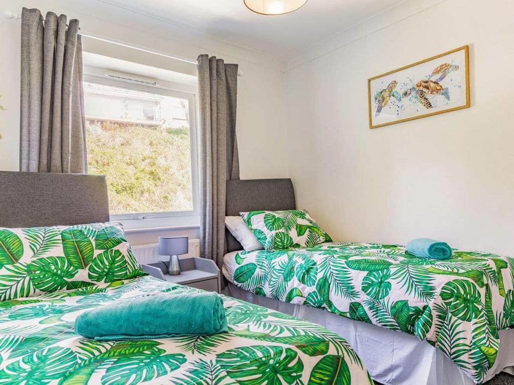a room with two beds and a window at Lovely Magnolia Apartment- 1king and 4 Single Accommodation Torquay in Torquay