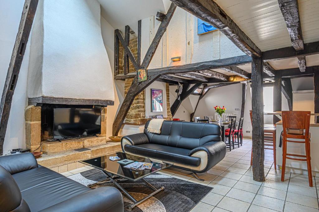 un salon avec un canapé et une cheminée dans l'établissement L'ARAMIS - Appartement Duplex de 110m2 au port de Vannes, à Vannes