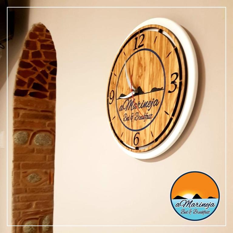 un reloj colgando en una pared junto a una jirafa en B&B aMarineja, en Nicotera Marina
