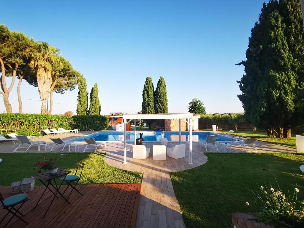 un jardin avec une piscine et un pavillon dans l'établissement Il Giardino dei Pini, à Paestum