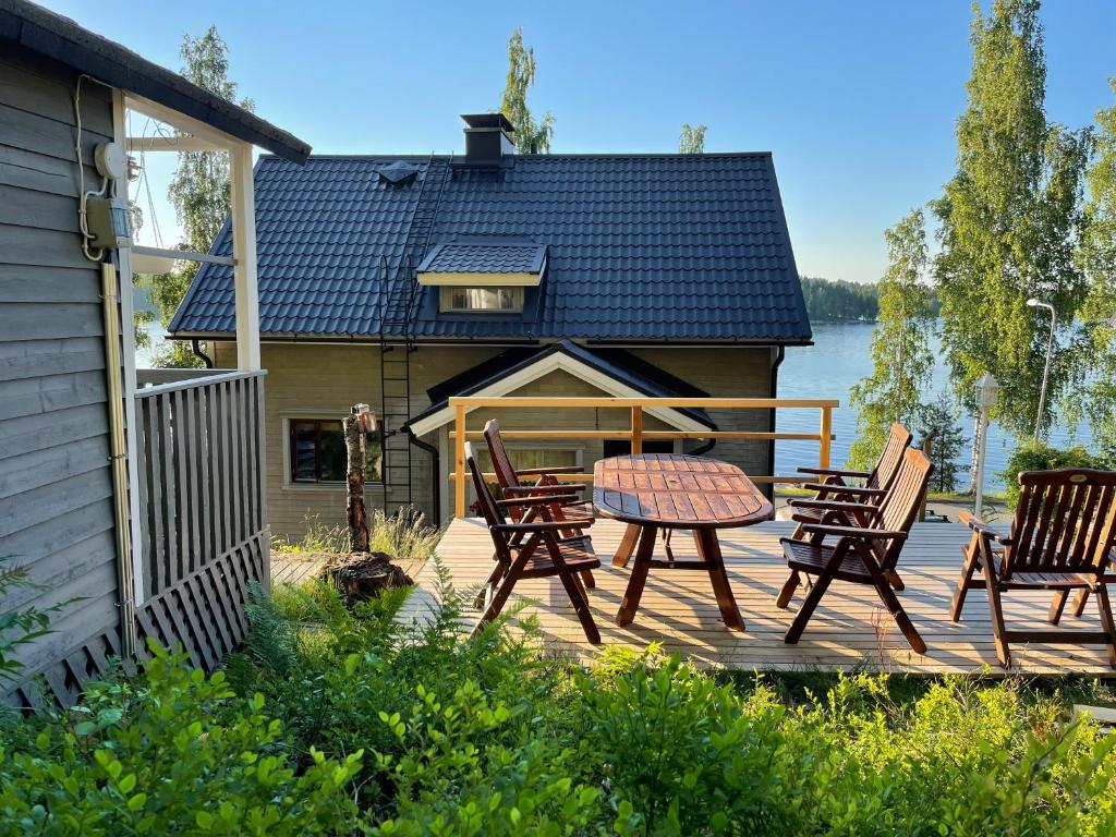 a deck with chairs and a table and a house at HAIKANTIE 17 in Jyväskylä