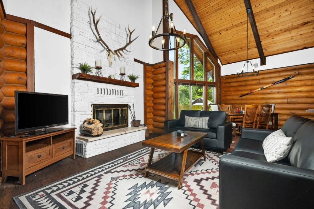 a living room with a tv and a fireplace at The Fernwood in Brightwood