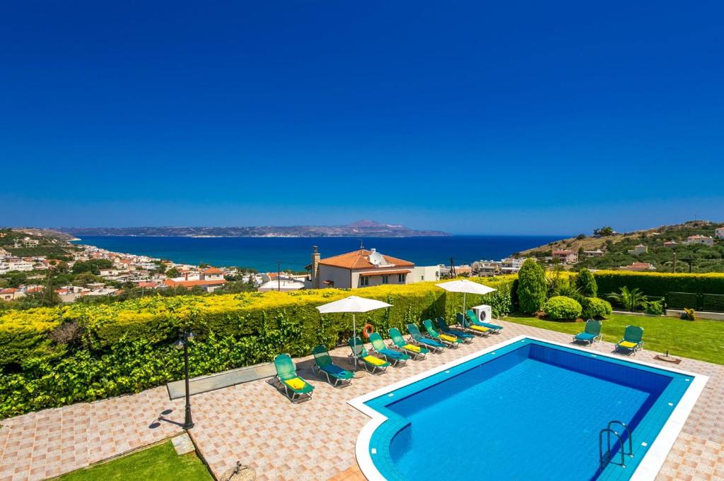a villa with a swimming pool and a view of the ocean at Villa Margarita Exi by Villa Plus in Kalyves