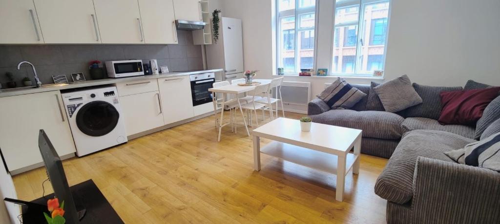 a living room with a couch and a table and a kitchen at Spacious 3 Bed Flat near Liverpool street, Spitalfields in London