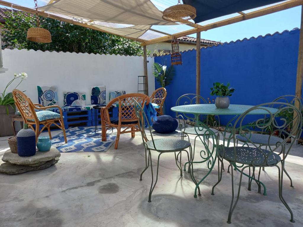 un patio con mesa, sillas y una pared azul en La terrasse Majorelle., en Le Passage