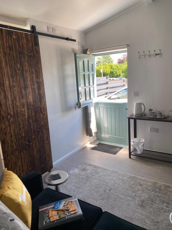 uma sala de estar com um sofá e uma porta de correr em Self-contained, Framlingham Snug, Private Parking, no cooking facilities em Framlingham