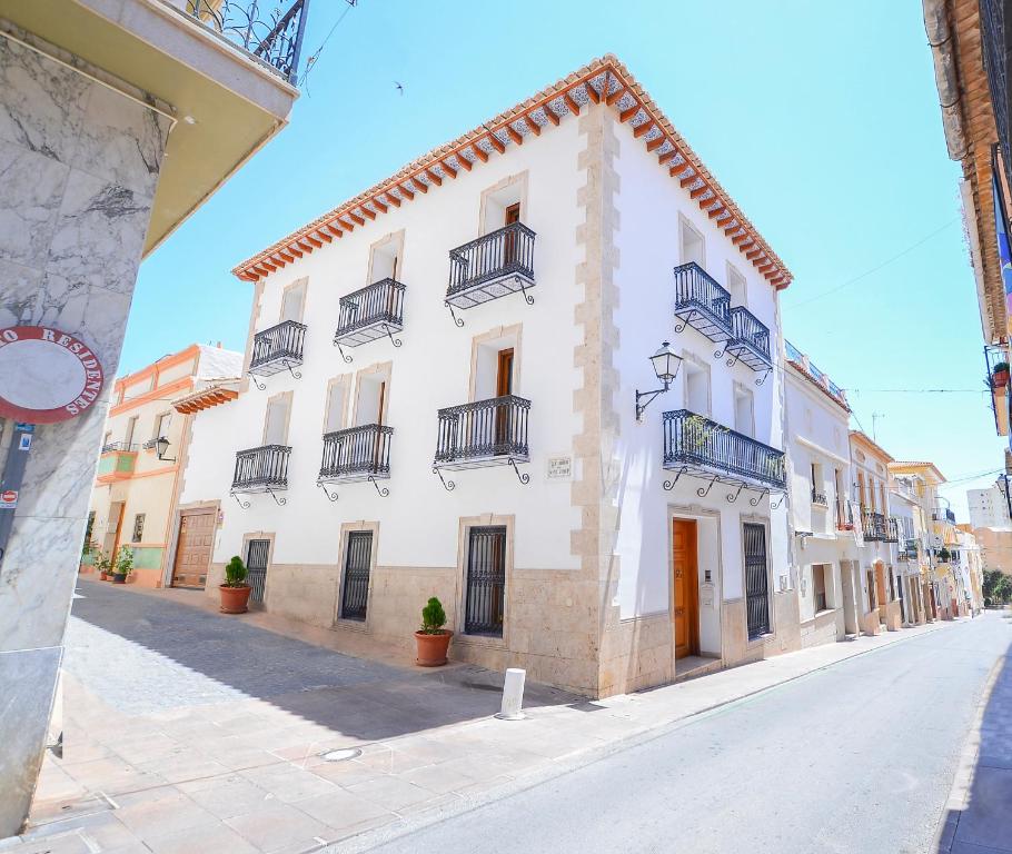 a large white building with balconies on a street at Casa Paquita in Calpe