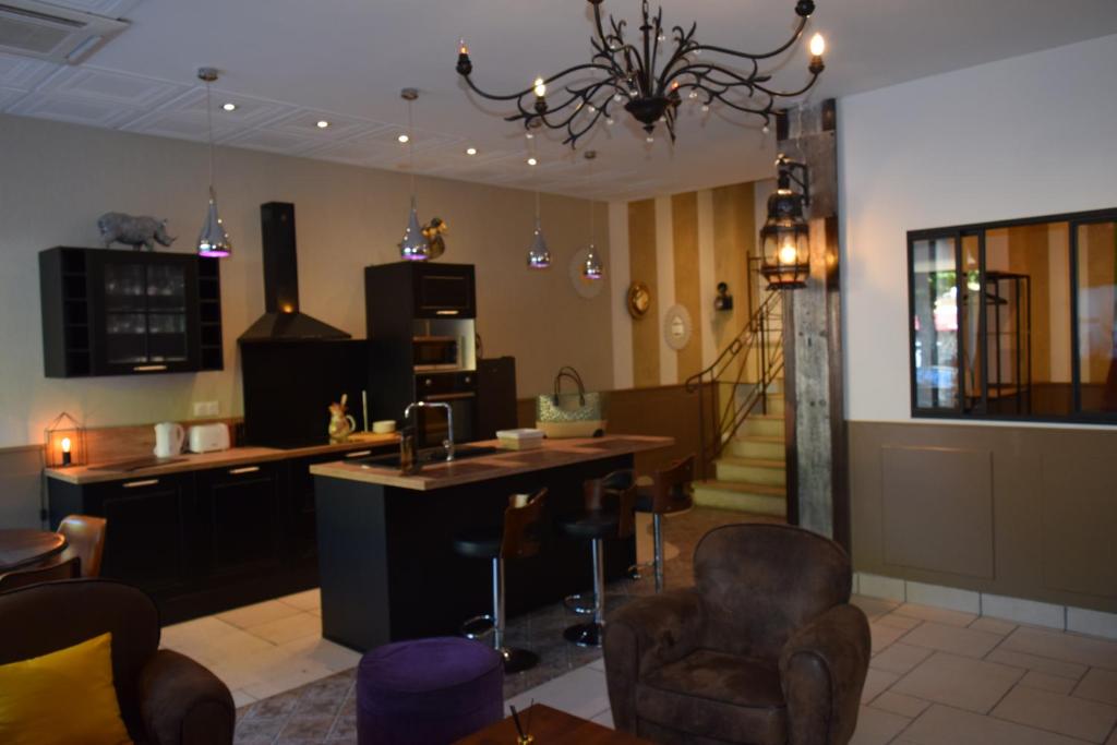 a living room with chairs and a kitchen and stairs at Hôtel Saint Albert in Sarlat-la-Canéda