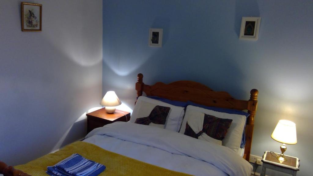 ein Schlafzimmer mit einem Bett und zwei Lampen an Tischen in der Unterkunft Cosy house for business travel and pleasure in Bickershaw